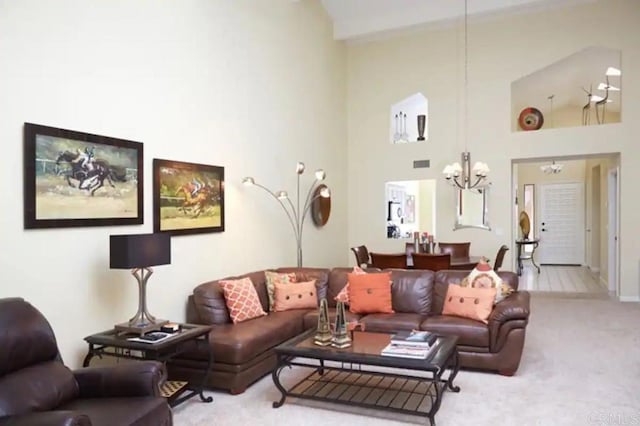 carpeted living room featuring high vaulted ceiling and a notable chandelier