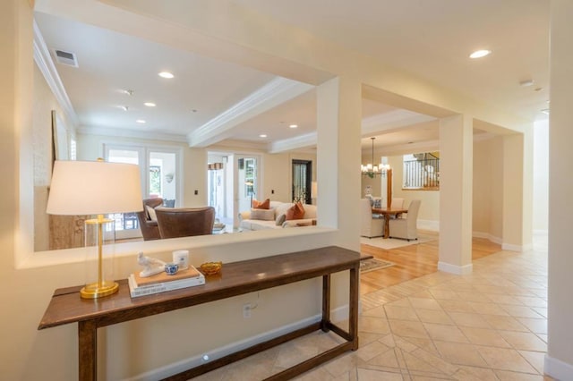 interior space with a notable chandelier, tile patterned floors, and ornamental molding