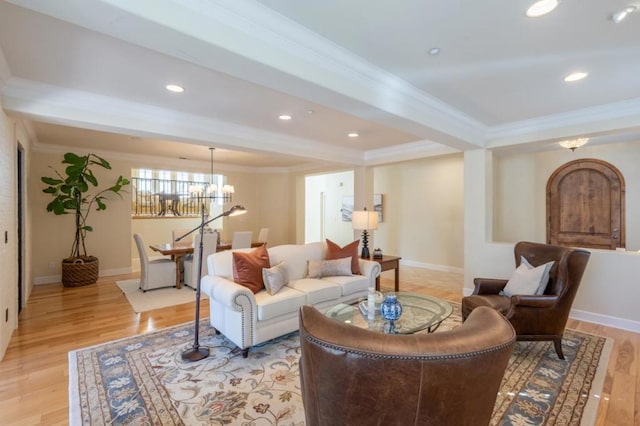 living room featuring light wood-type flooring, beamed ceiling, crown molding, and a chandelier