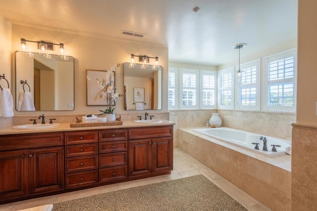 bathroom featuring vanity, tile patterned floors, and tiled tub