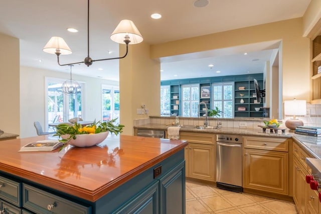 kitchen with an inviting chandelier, sink, hanging light fixtures, butcher block countertops, and light tile patterned floors