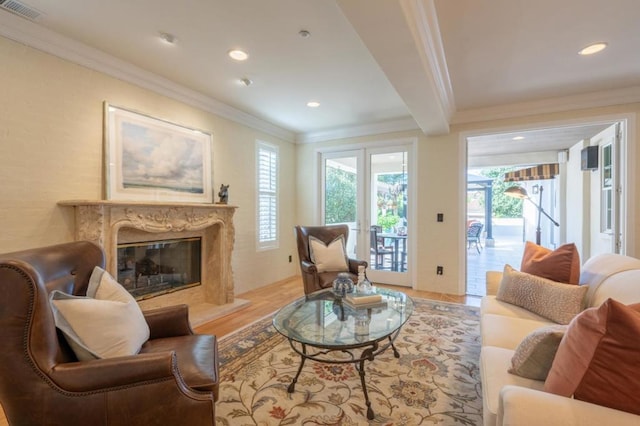 living room featuring light hardwood / wood-style floors, crown molding, and a premium fireplace