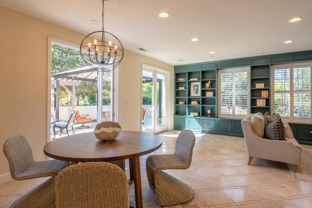 dining space featuring french doors, built in shelves, a wealth of natural light, and a notable chandelier