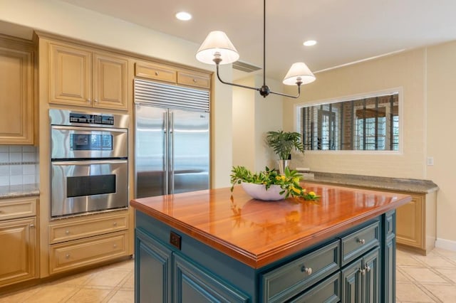 kitchen featuring pendant lighting, a center island, stainless steel appliances, tasteful backsplash, and butcher block countertops