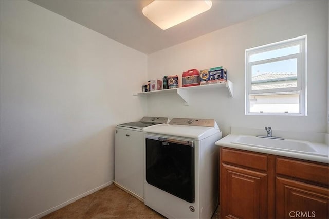 washroom featuring cabinets, washing machine and dryer, and sink