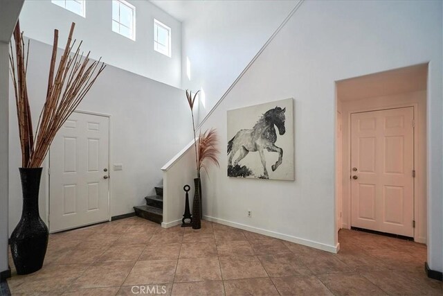 tiled foyer featuring a towering ceiling