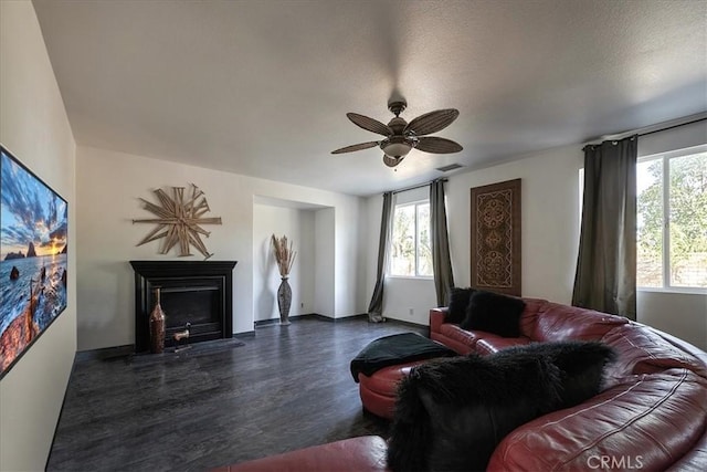 living room featuring a textured ceiling, dark hardwood / wood-style flooring, and ceiling fan