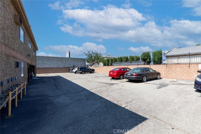 uncovered parking lot featuring fence