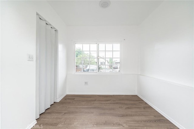 unfurnished room with baseboards and wood finished floors