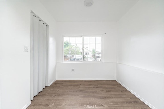 empty room with baseboards and wood finished floors