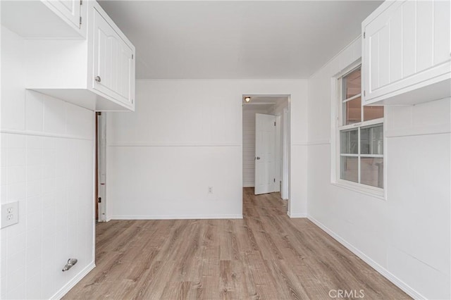 empty room with light wood-style flooring and baseboards