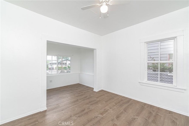 spare room with ceiling fan, baseboards, and wood finished floors