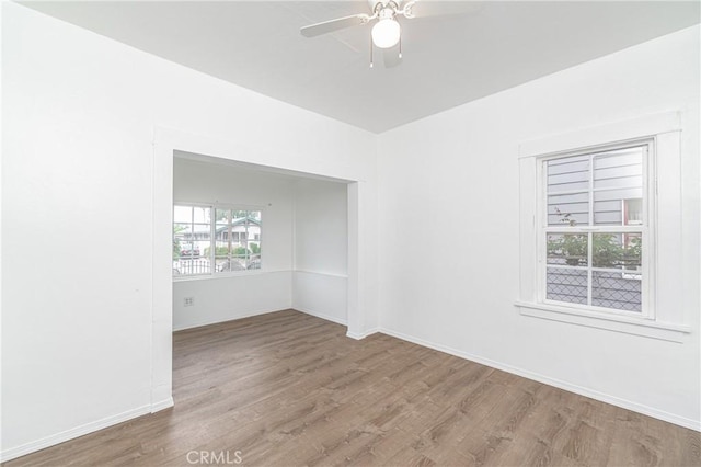 empty room featuring baseboards, ceiling fan, and wood finished floors
