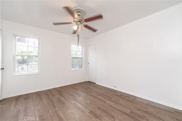 spare room with a ceiling fan, baseboards, and wood finished floors