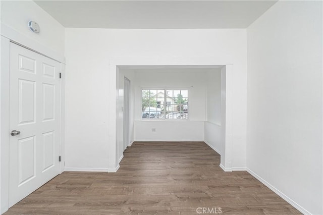 empty room with baseboards and wood finished floors