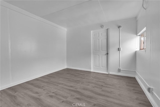 spare room featuring wood finished floors and baseboards