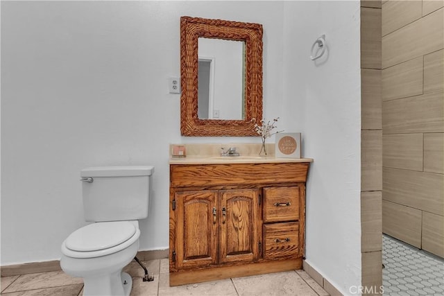 half bath with toilet, baseboards, and vanity