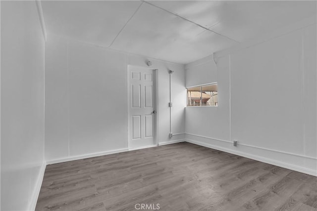 empty room featuring baseboards and wood finished floors