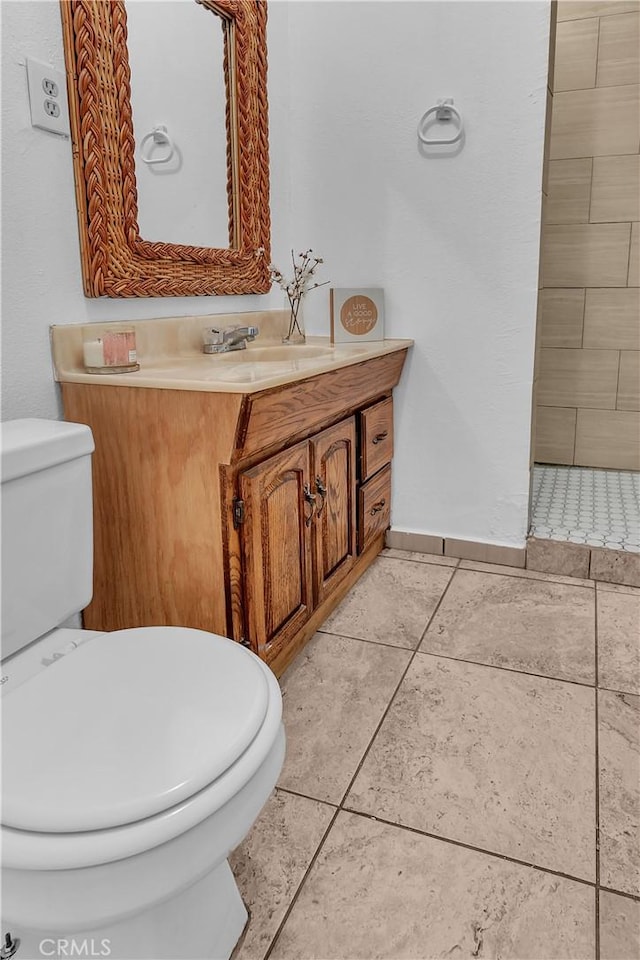 bathroom with baseboards, vanity, toilet, and tile patterned floors