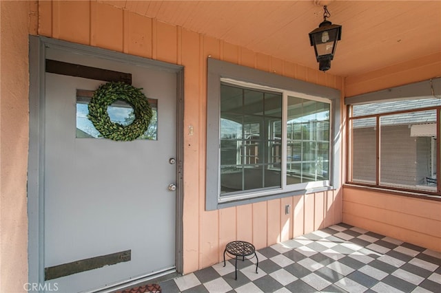 view of exterior entry with covered porch and board and batten siding