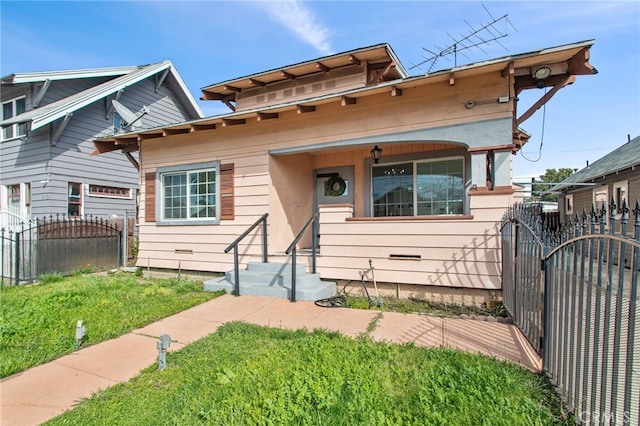 view of front of house featuring a front lawn, fence, and a gate