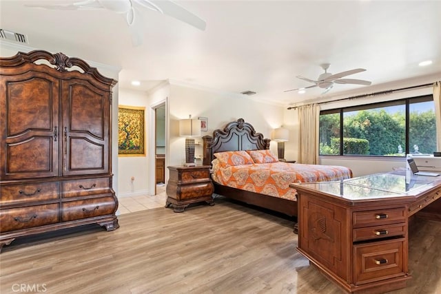 bedroom featuring ceiling fan, crown molding, and light hardwood / wood-style flooring