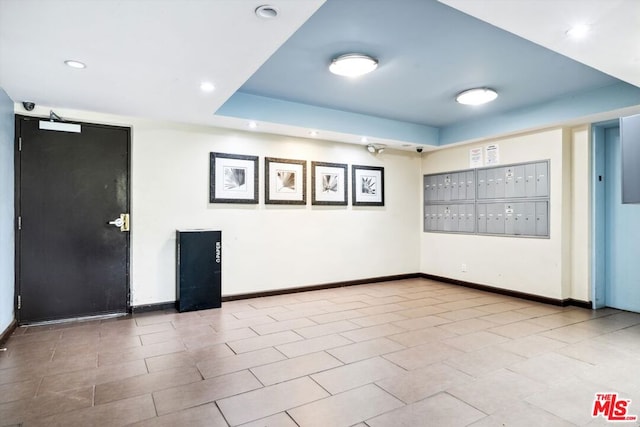 unfurnished room with a mail area and light tile patterned floors