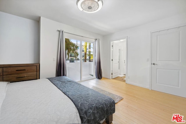 bedroom with wood-type flooring, ensuite bath, and access to exterior