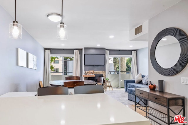 kitchen with backsplash, hanging light fixtures, plenty of natural light, and light hardwood / wood-style floors