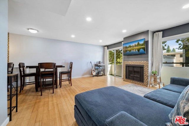 living room with a wealth of natural light, light hardwood / wood-style floors, and a fireplace