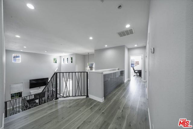 hall with an inviting chandelier and light hardwood / wood-style flooring