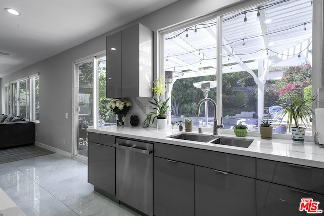 kitchen with gray cabinetry, dishwasher, and sink