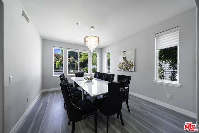 dining room with dark wood-type flooring and a notable chandelier