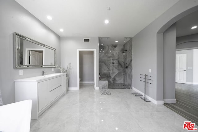 bathroom featuring tiled shower, vanity, and toilet