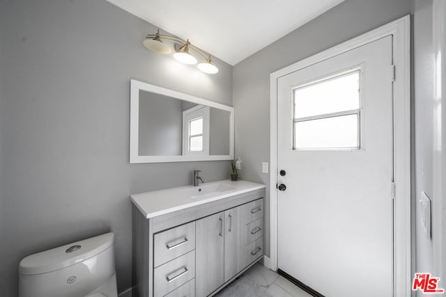 bathroom featuring plenty of natural light, vanity, and toilet