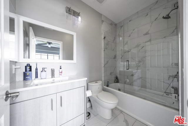 full bathroom featuring vanity, ceiling fan, toilet, and shower / bath combination with glass door