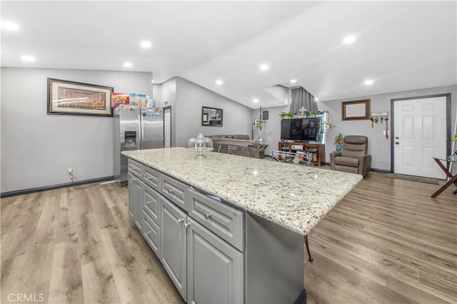 kitchen featuring gray cabinets, a center island, light wood-type flooring, and stainless steel refrigerator with ice dispenser