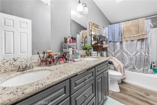 full bathroom featuring shower / bath combo, hardwood / wood-style floors, vaulted ceiling, toilet, and vanity