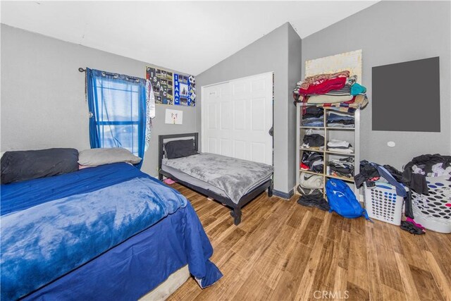 bedroom with lofted ceiling and wood-type flooring