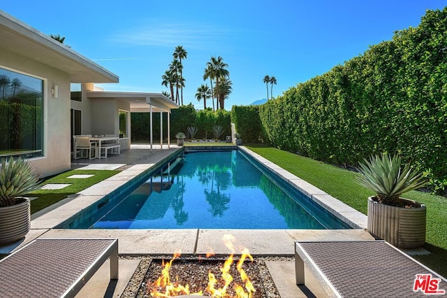 view of swimming pool with a patio area and an outdoor fire pit