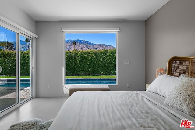 bedroom featuring access to exterior and concrete floors