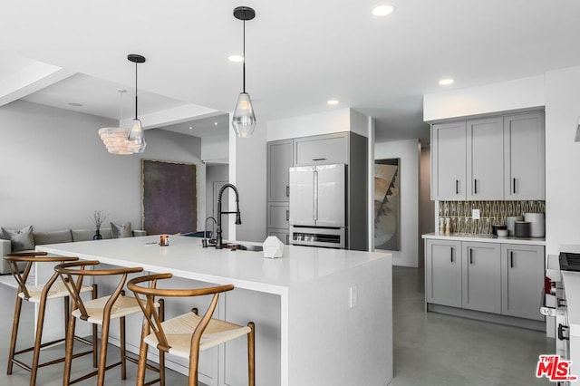 kitchen featuring white fridge, a center island with sink, and sink