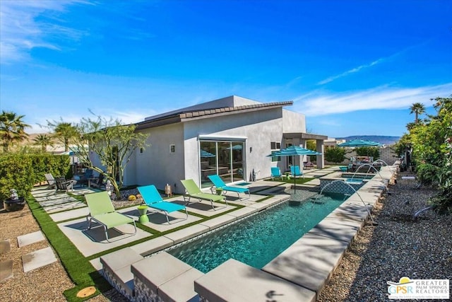 back of house featuring pool water feature, a fenced in pool, and a patio area