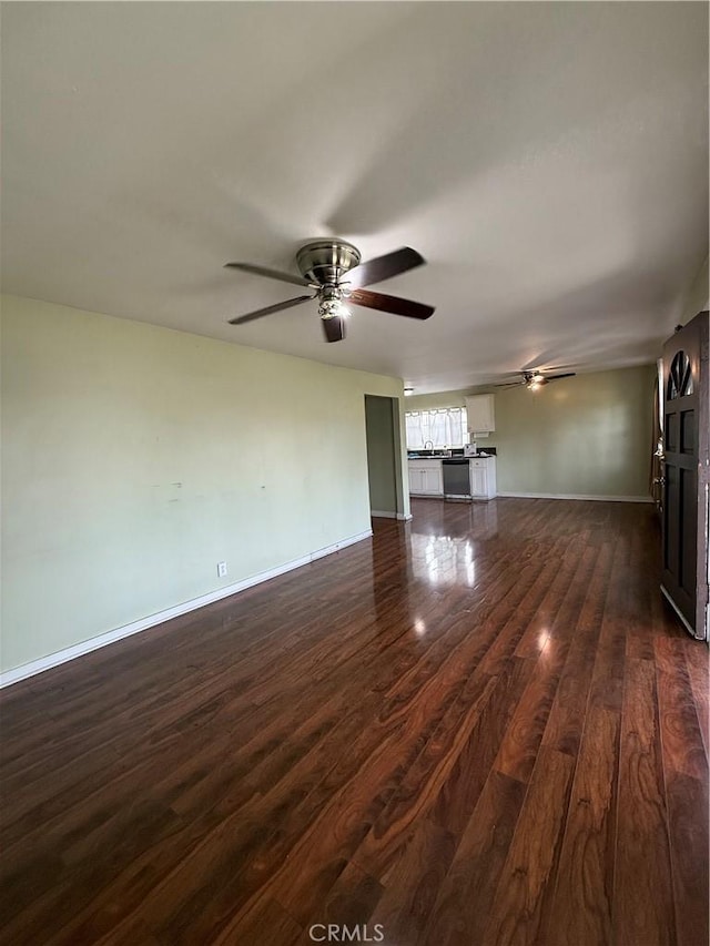 unfurnished living room with dark wood-type flooring and ceiling fan