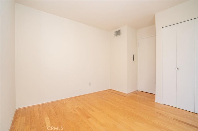 unfurnished bedroom featuring hardwood / wood-style floors and a closet