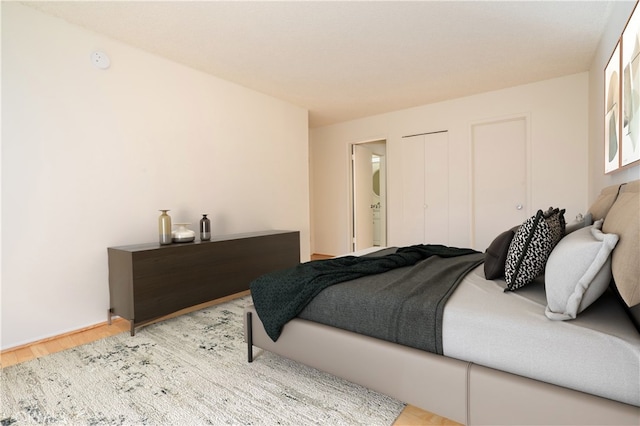 bedroom with light hardwood / wood-style floors and connected bathroom