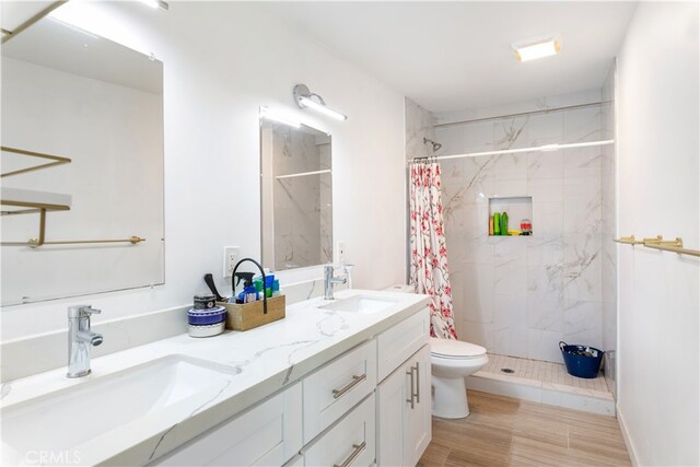 bathroom featuring hardwood / wood-style floors, toilet, vanity, and curtained shower