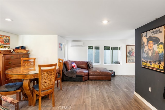 dining area featuring a wall unit AC and hardwood / wood-style floors