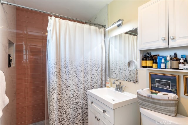 bathroom with curtained shower, vanity, and toilet