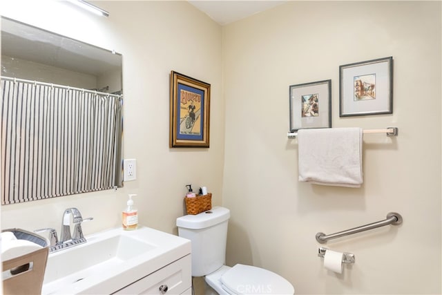 bathroom with walk in shower, vanity, and toilet